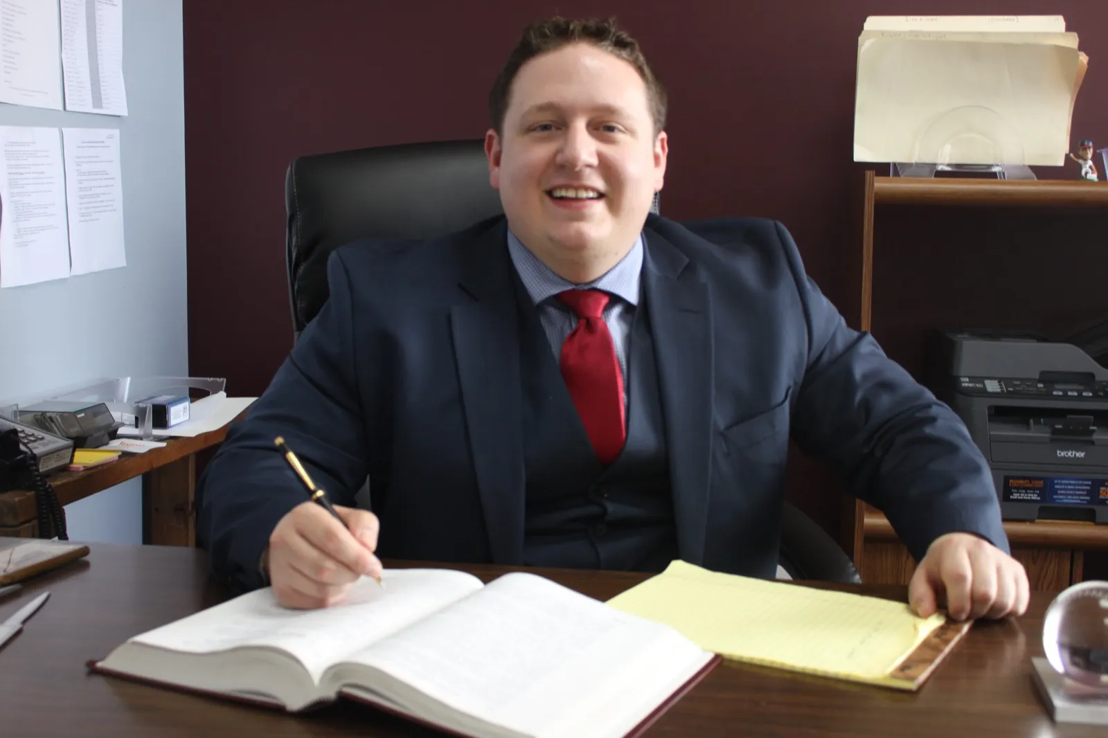 Attorney Mark Cicero writing on a yellow legal pad at his desk